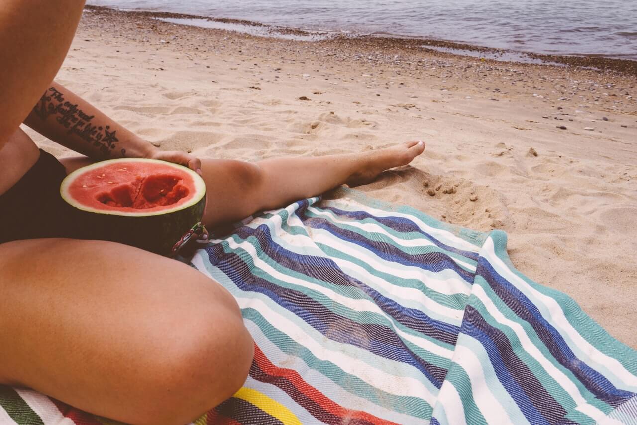 dziewczyna jedząca owoc na plaży